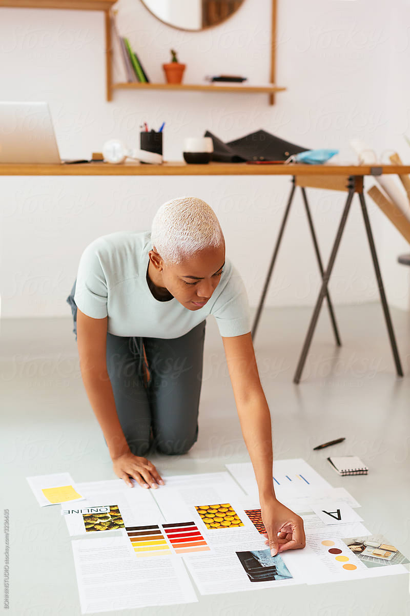 Black designer working on project on floor
