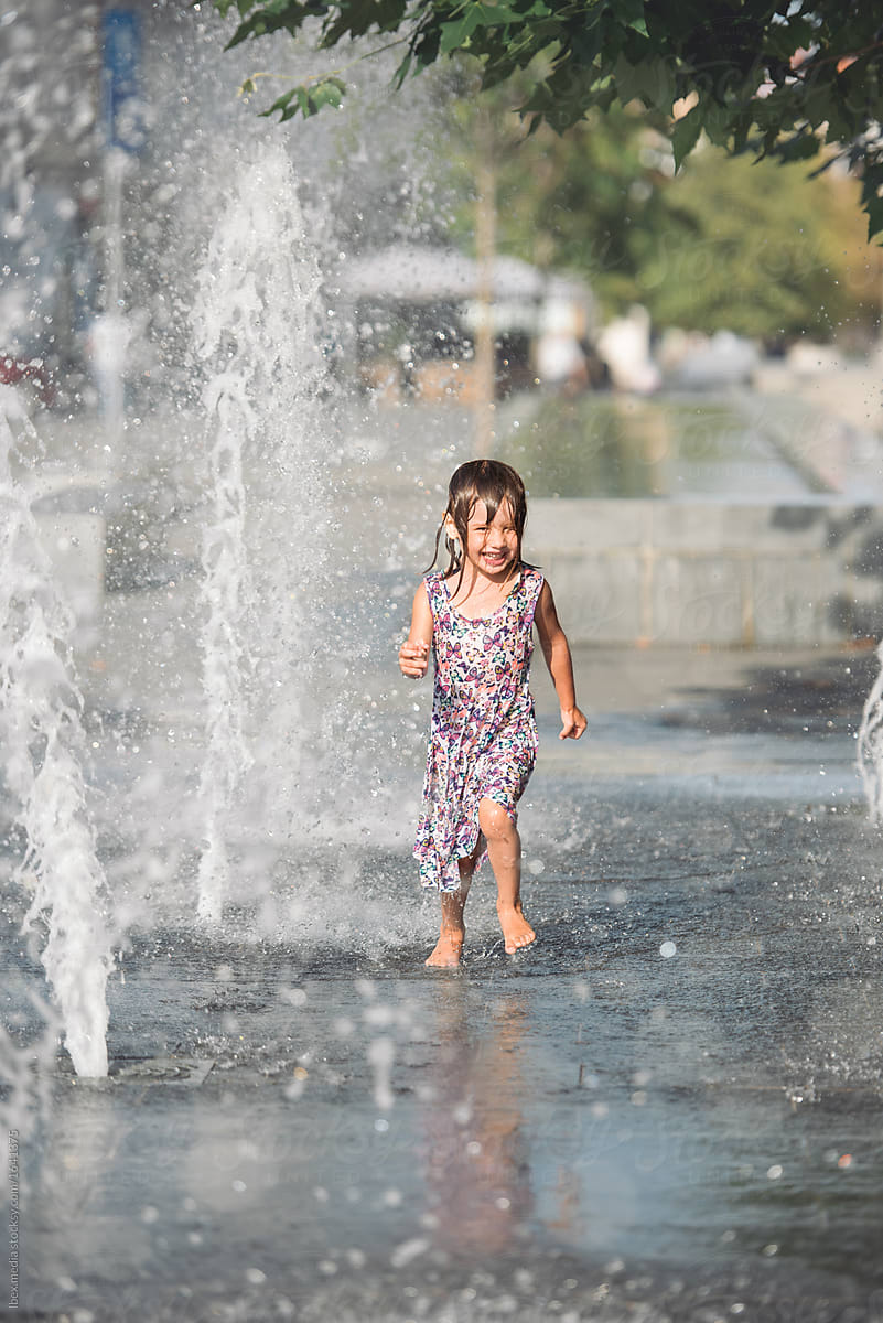 Portrait of enthusiastic girl refreshing in the fountain