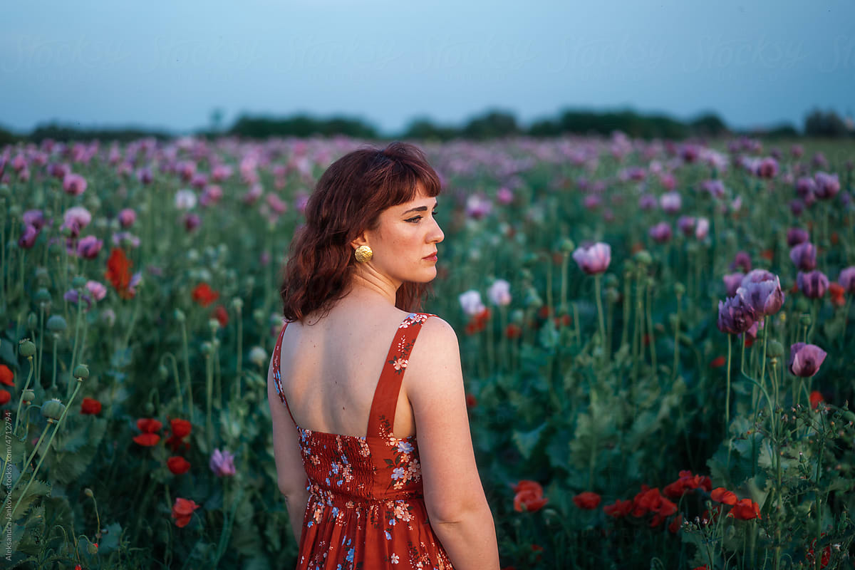 Stylish Redhead Woman In The Floral Dress Among The Flowers