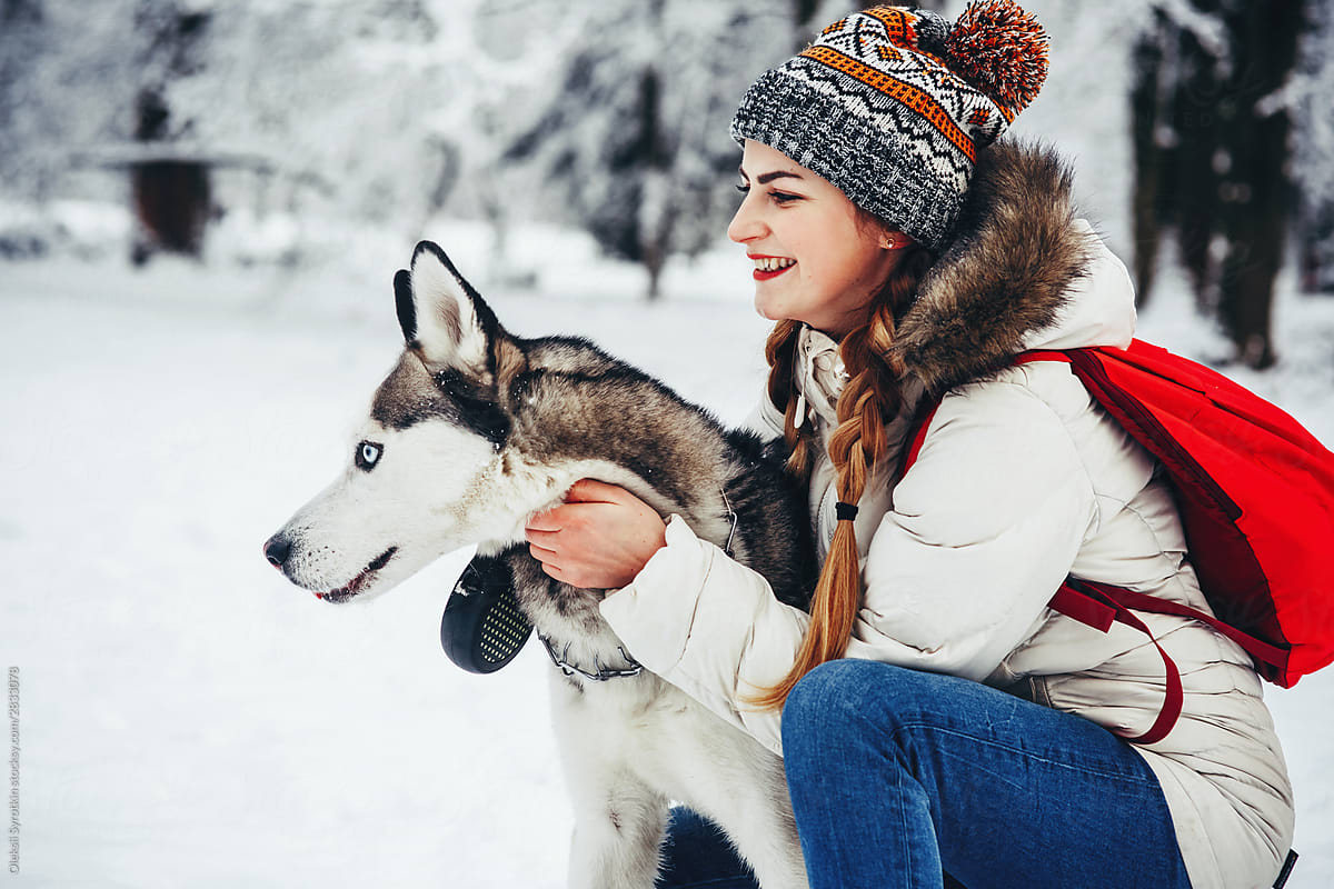 Atmosphere winter photo of cute girl with her dog.