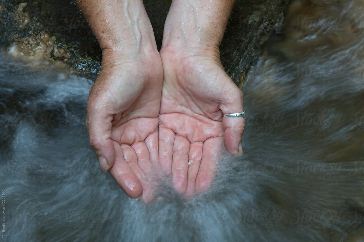 A pair of hands cupped in running water