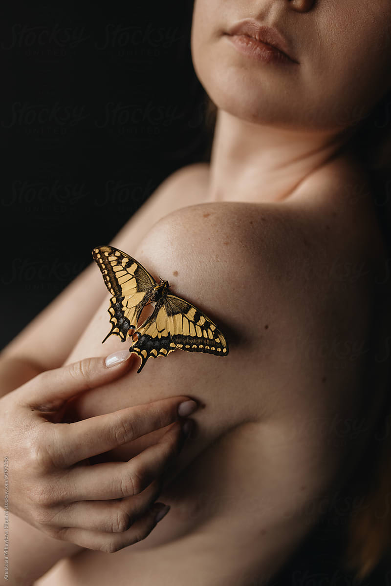 Close up photo of the skin texture of woman\'s shoulder and butterfly