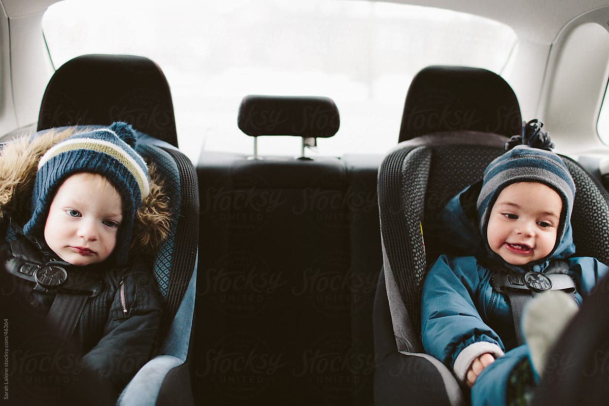 Two little boys in carseats in the their snowsuits