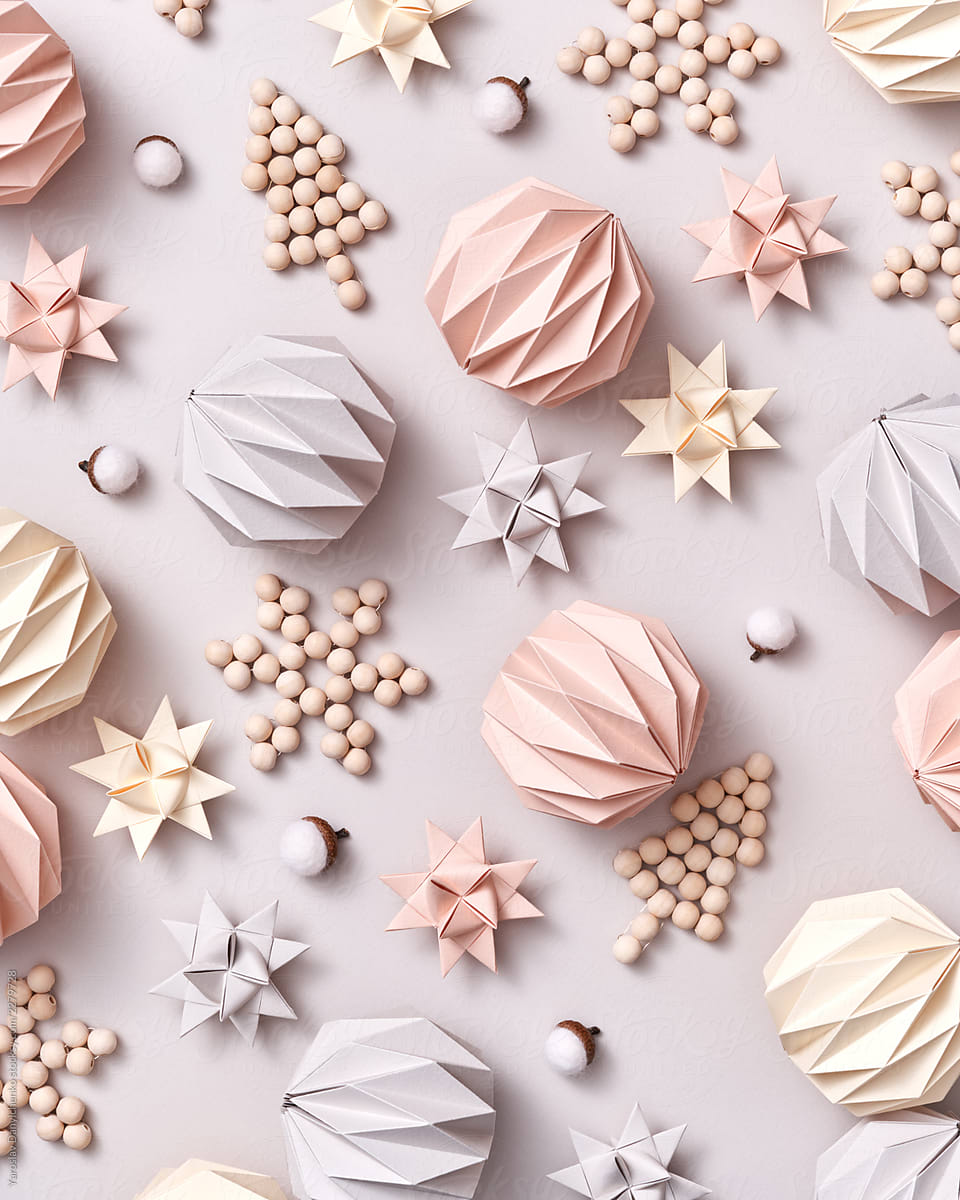 Handcraft wooden decorative Christmas trees, paper origami balls and stars on a gray background. Christmas layout. Flat lay