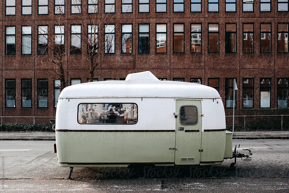 Parked oldfashioned camper-trailer on house
