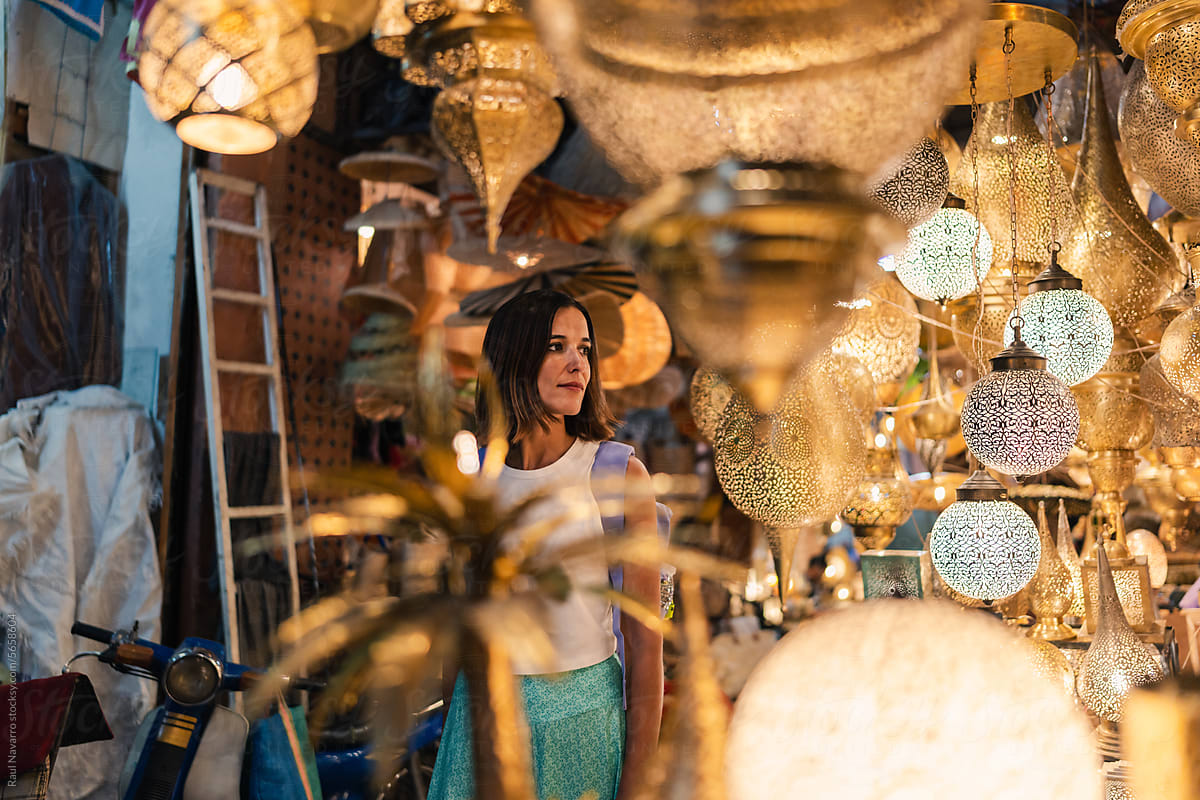 woman strolling through a bazaar surrounded by lanterns
