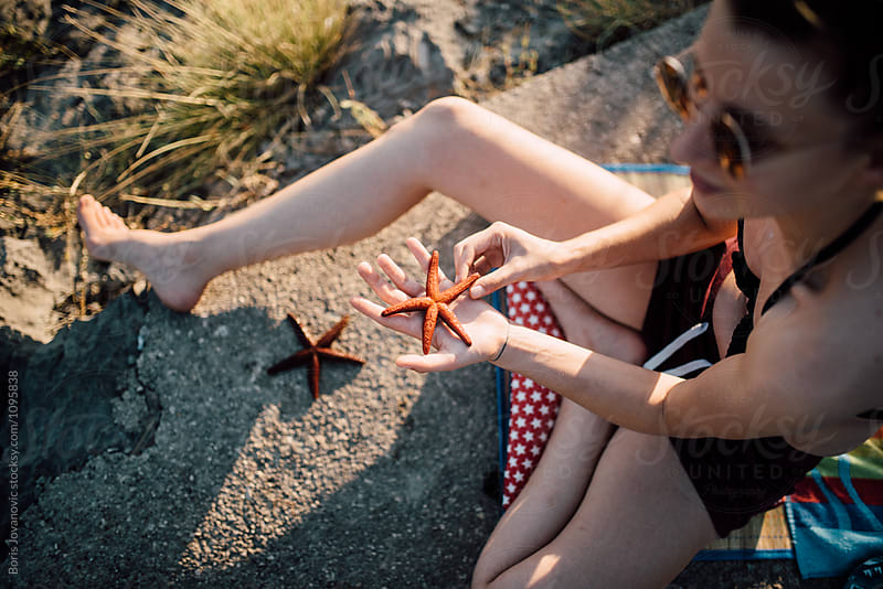 Close up of a sea star on the hand of a young woman