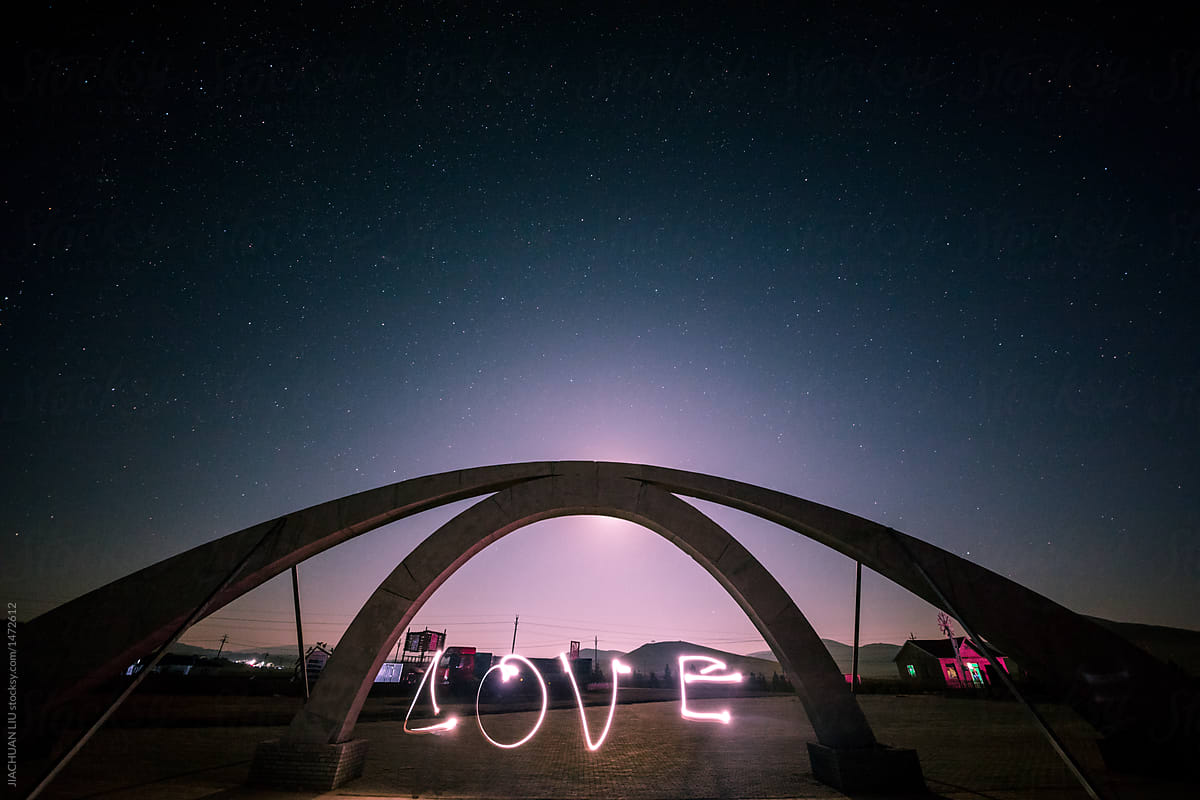 Writing the word \'love\' with phone light under the Galaxy.