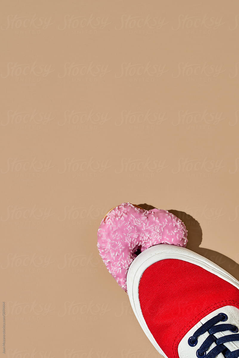 someone steps on a pink heart-shaped donut