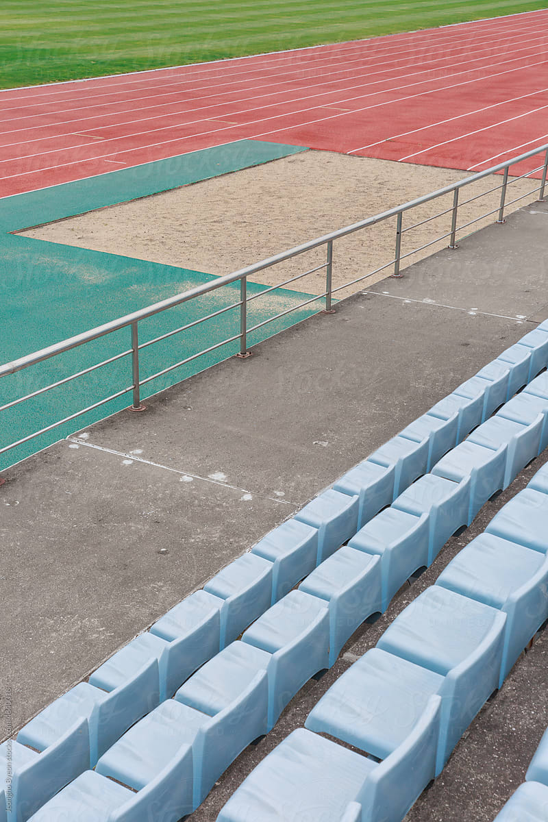 Close-up of track and sky blue stands in the stadium.