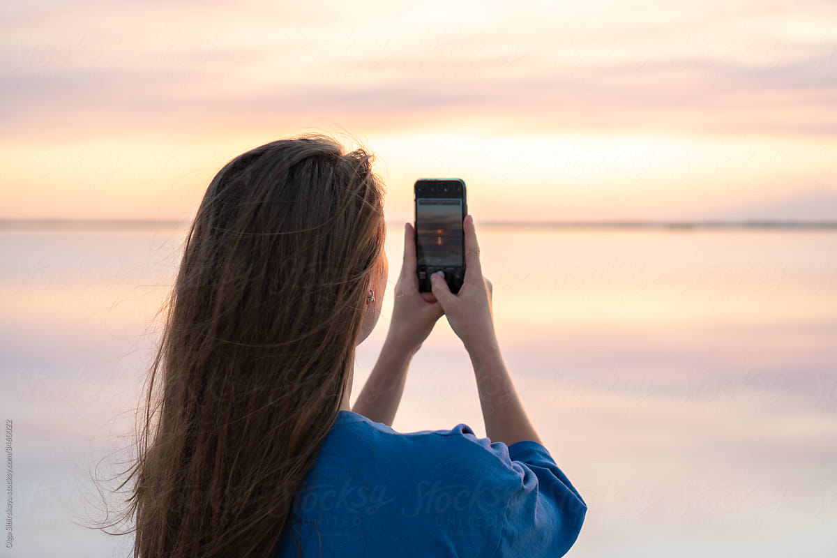 Woman take photo of sunset