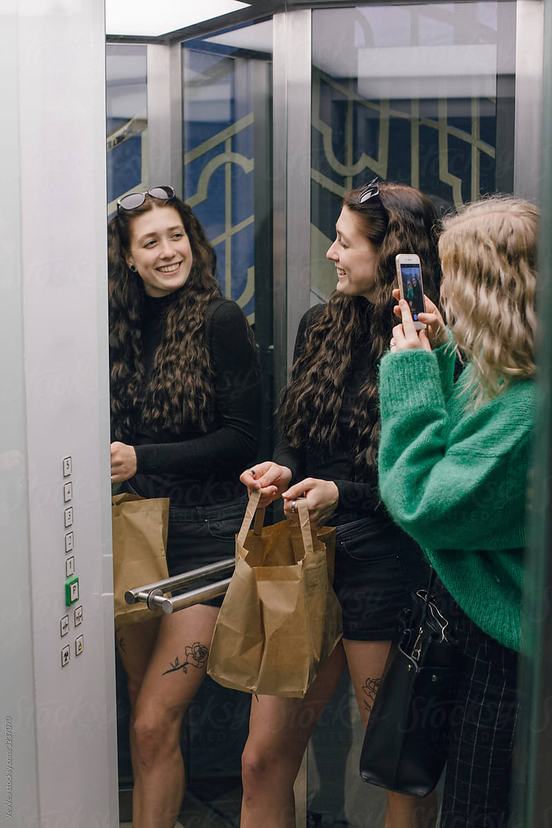 Two young women in elevator of the building
