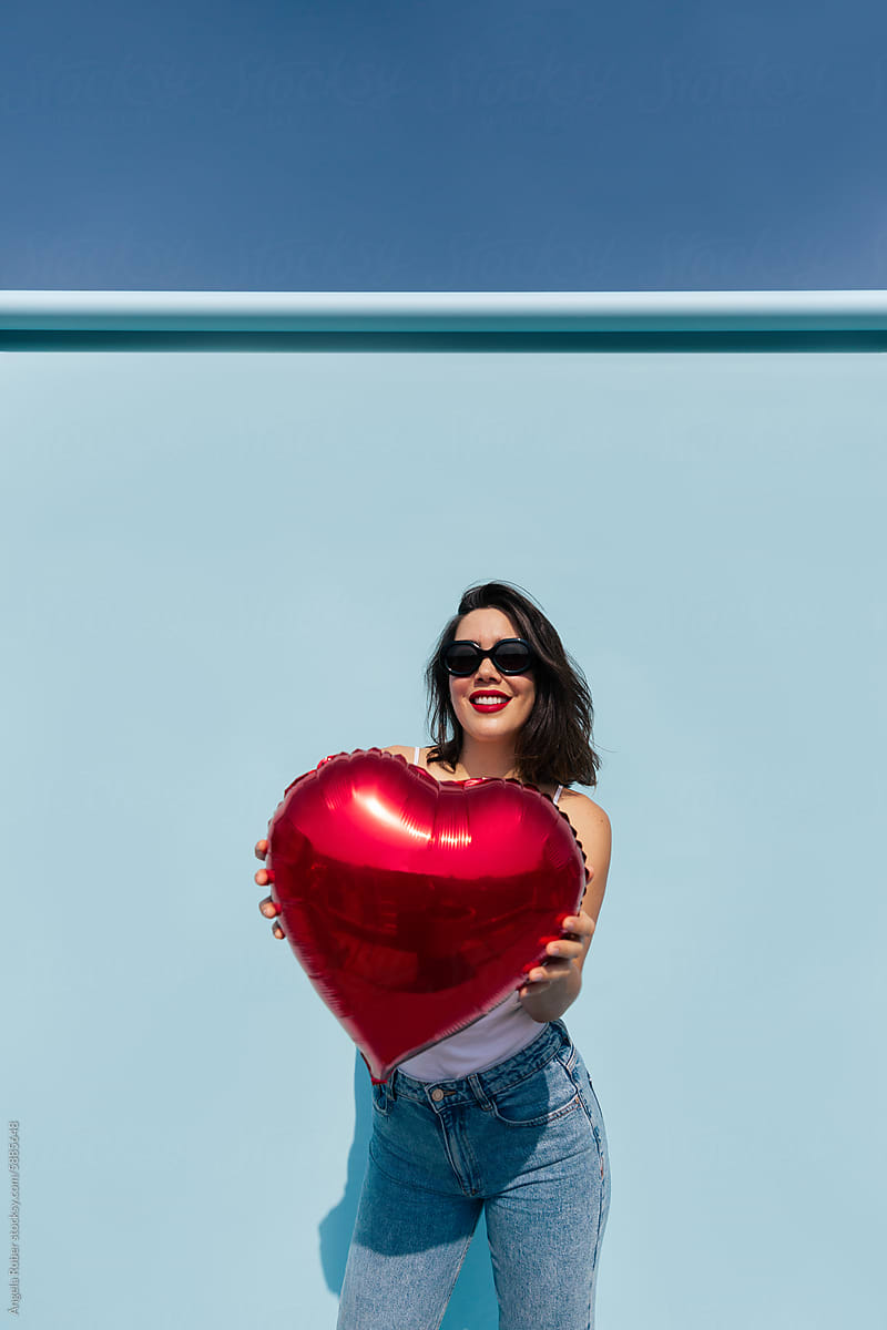 Woman Embracing a Red Heart Balloon