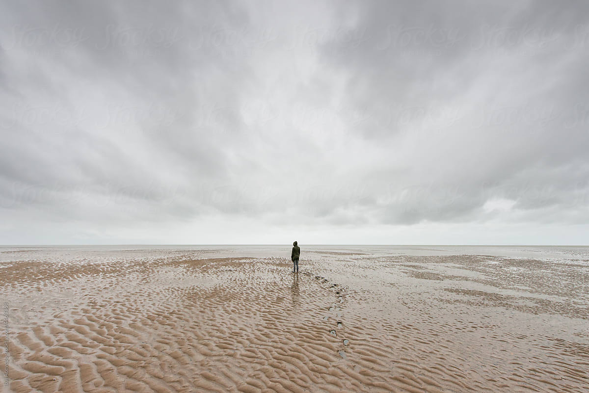 Woman standing on the beach in the  middle of nowhere
