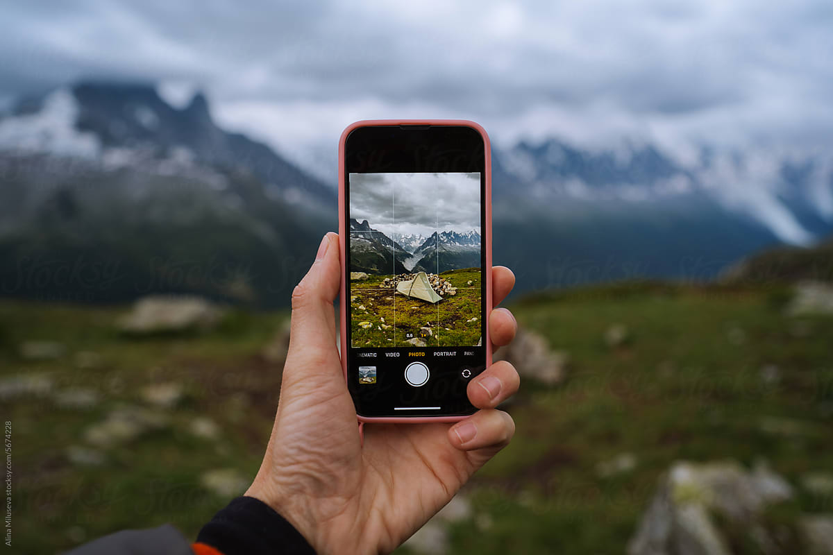 Camping Tent Against Mountain Peaks On The Phone Screen