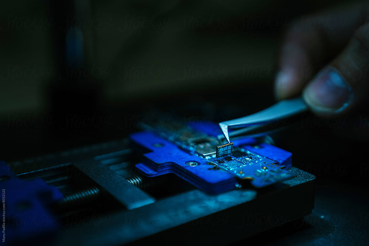 Engineer inserting microchip into micro scheme
