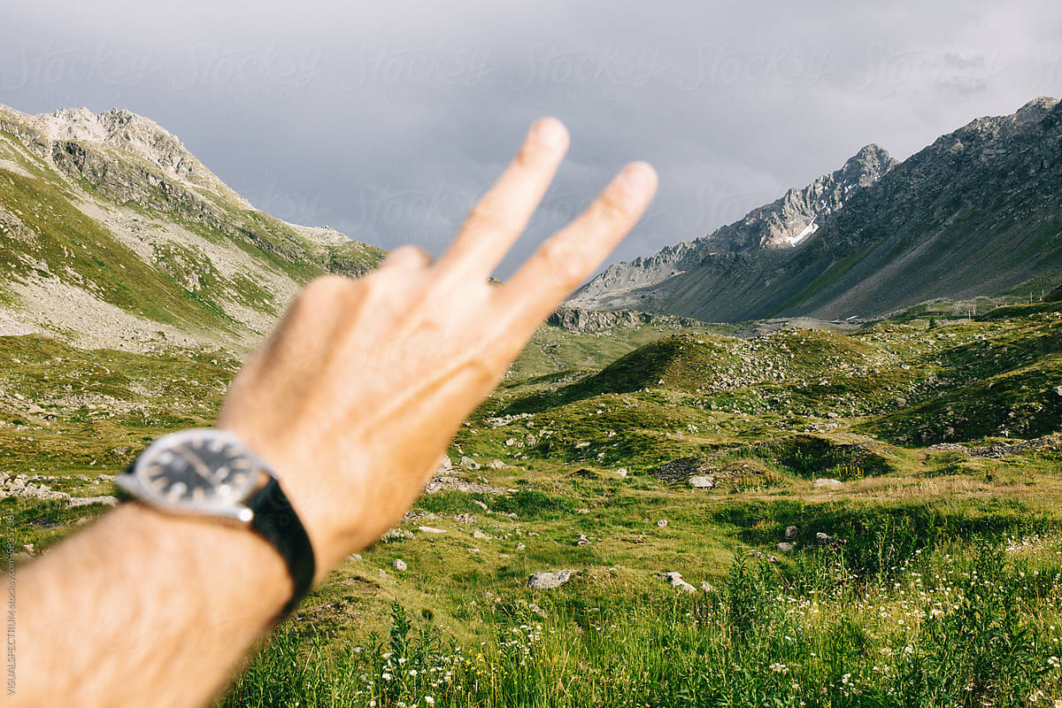 Peace Hand Gesture With Alpine Mountain Landscape in Background