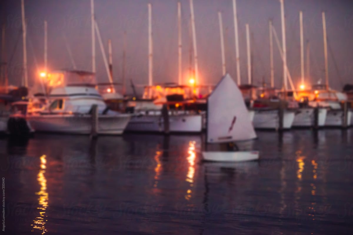 A little dinghy returns home to the yacht club at dusk