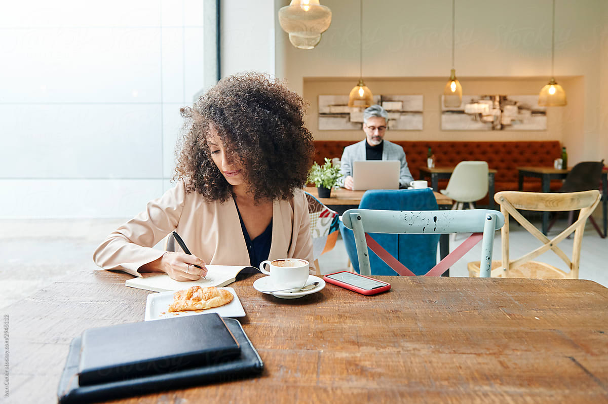 Businesswoman writing notes in a cafe