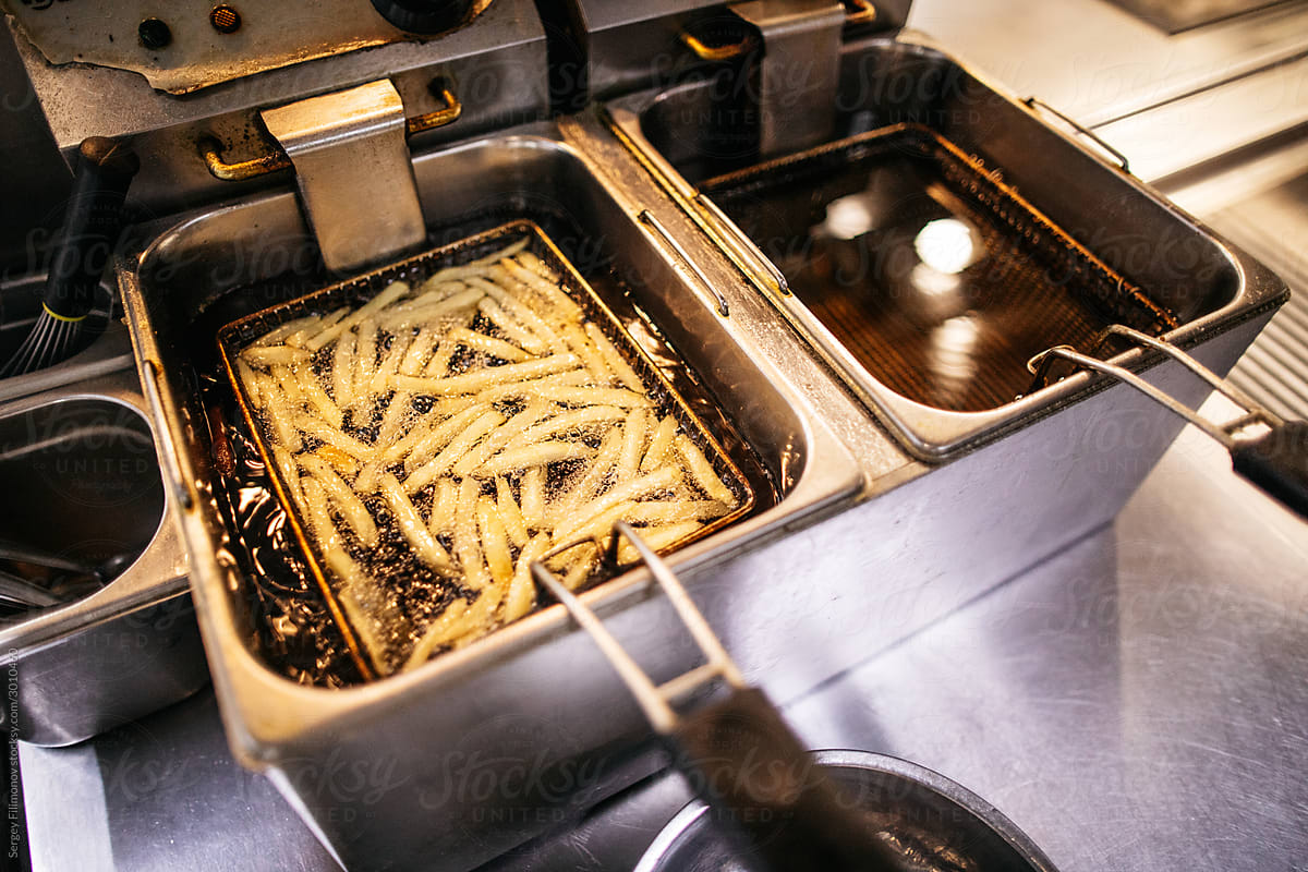 French fries in fryer in restaurant kitchen