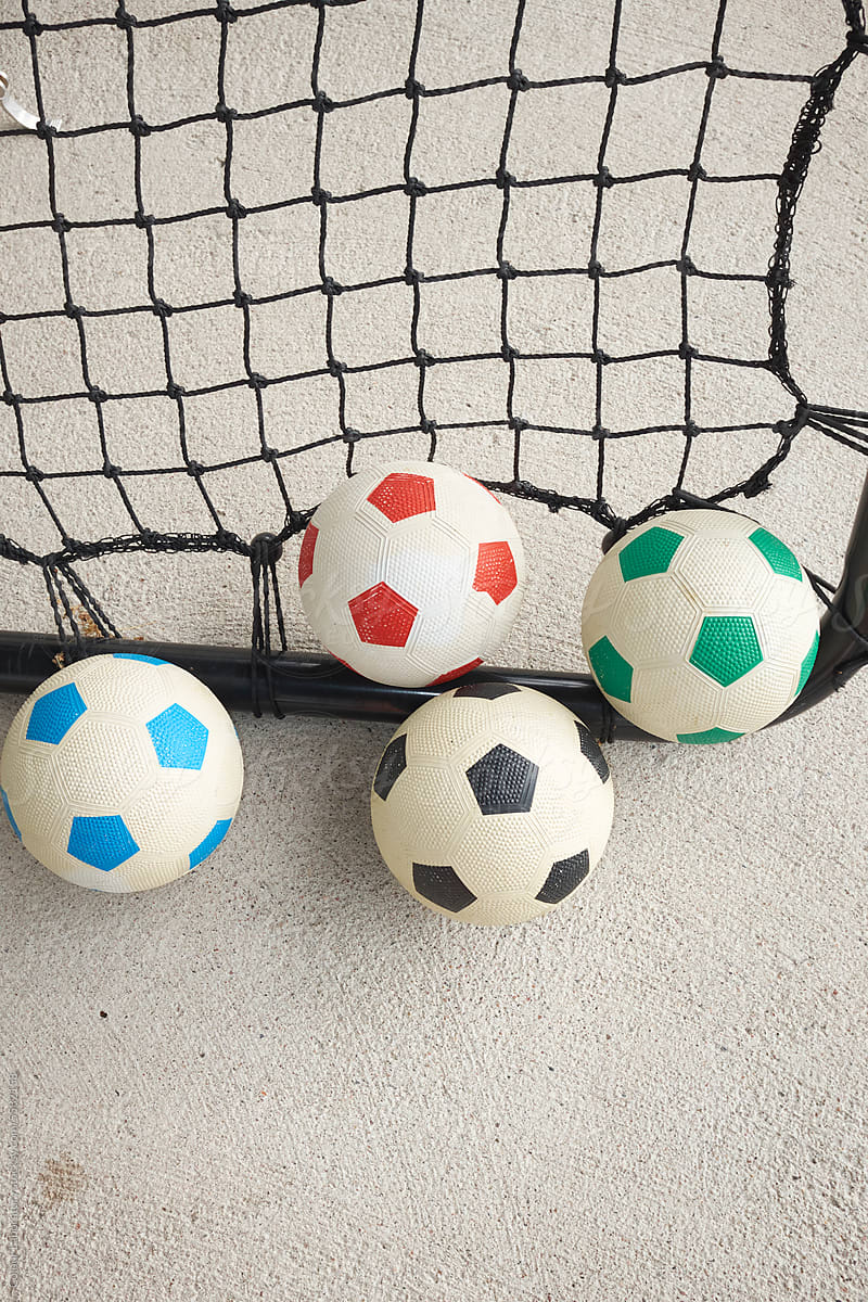 Minimal photo of footballs on goal net with concrete background
