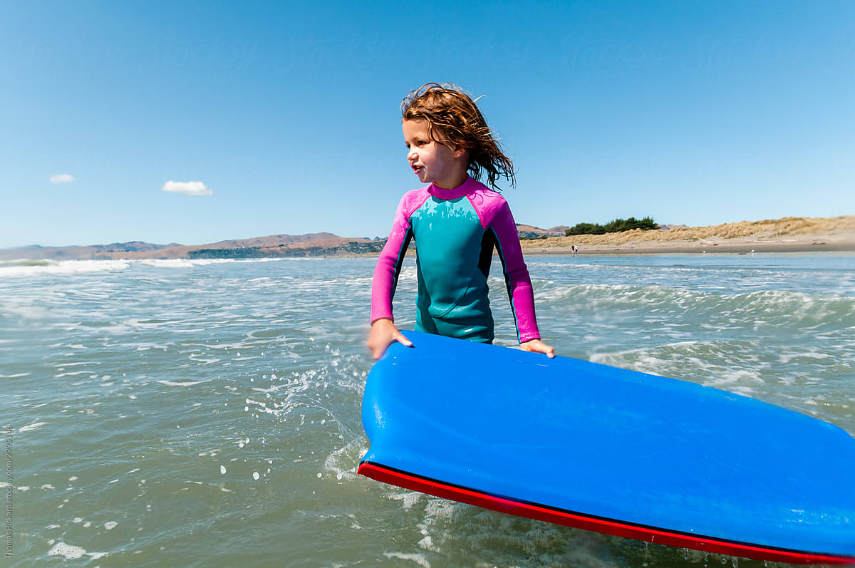 Girl going surfing. New Zealand.