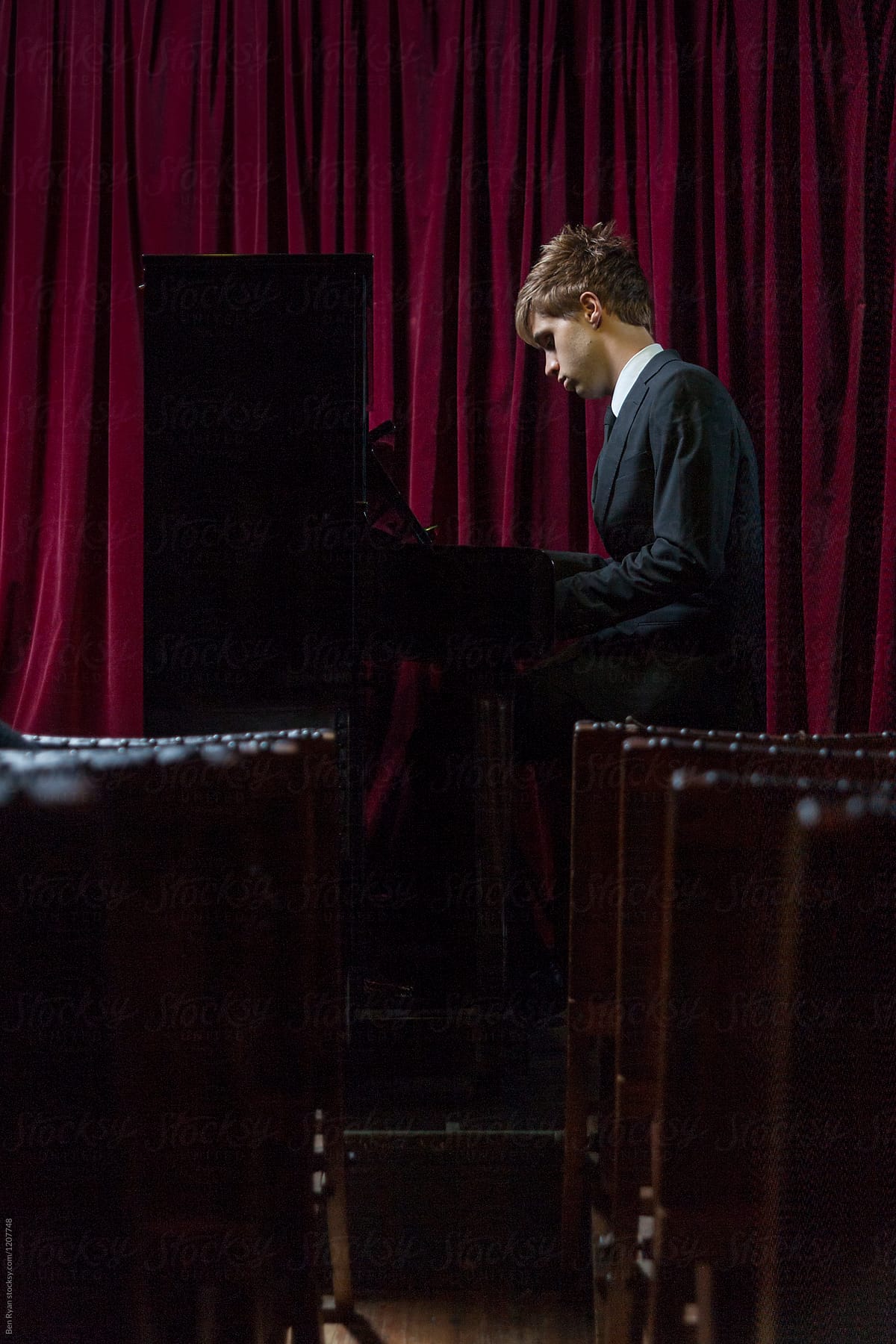 Young male pianist performing in empty venue