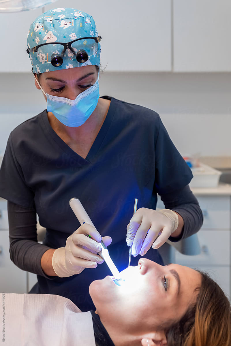 Orthodontist making a dental cleaning to patient