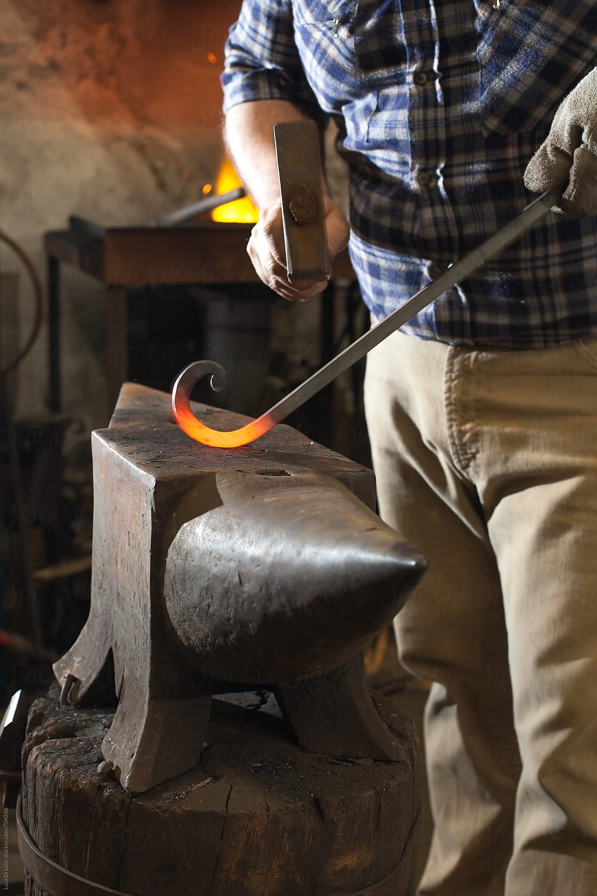 Blacksmith shaping a red-hot iron rod