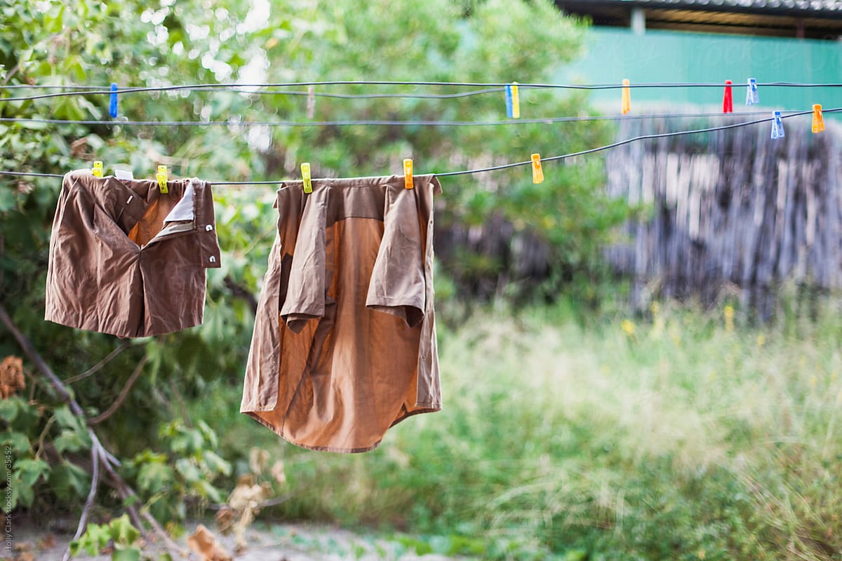 Child\'s school uniform hanging to dry on clothesline