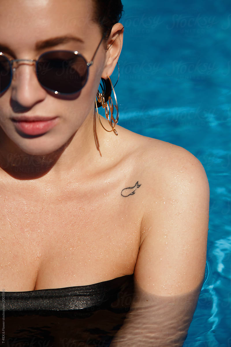 Beautiful woman in bikini and sunglasses in water