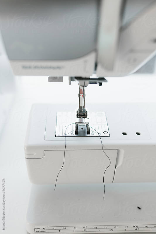 close up of sewing machine in bright white studio