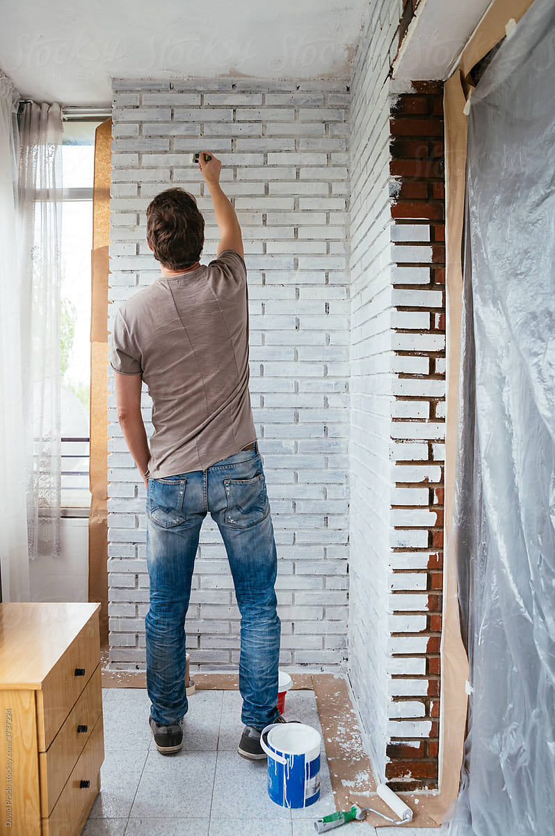 Unrecognizable Man painting wall at home