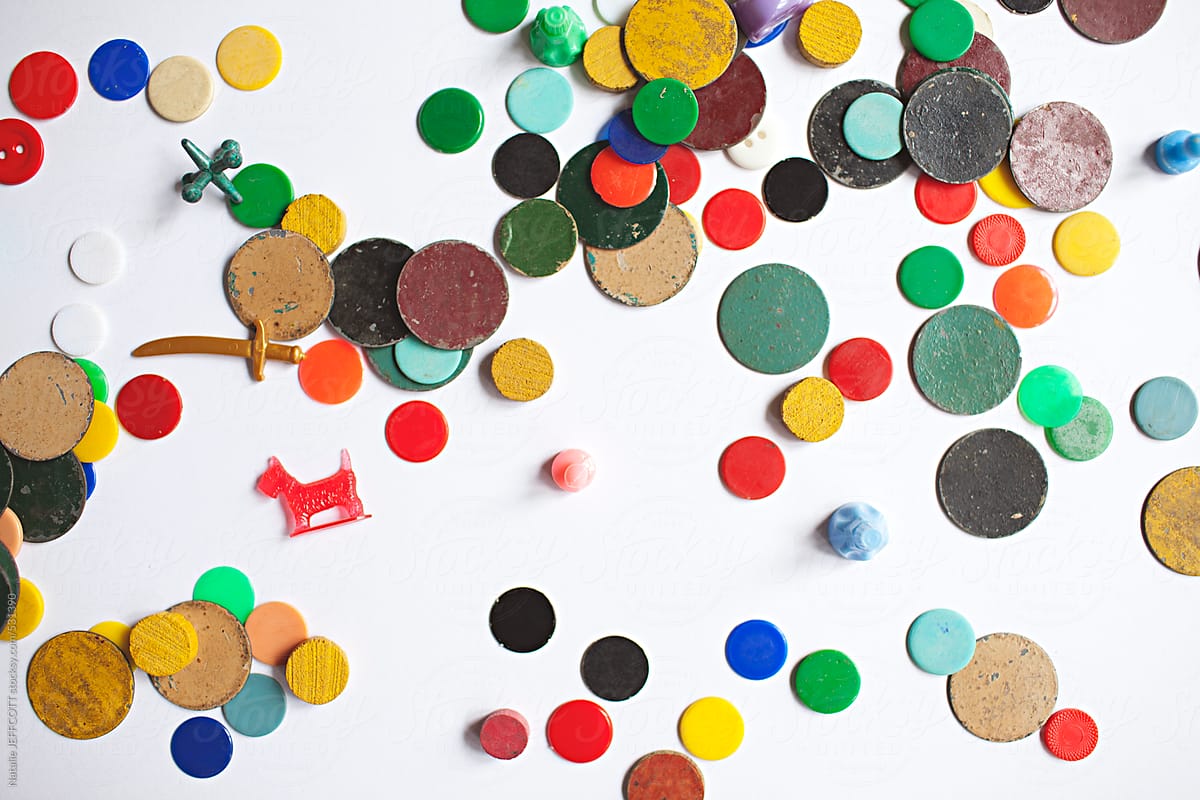 a collection of colourful vintage game pieces scattered on a white background