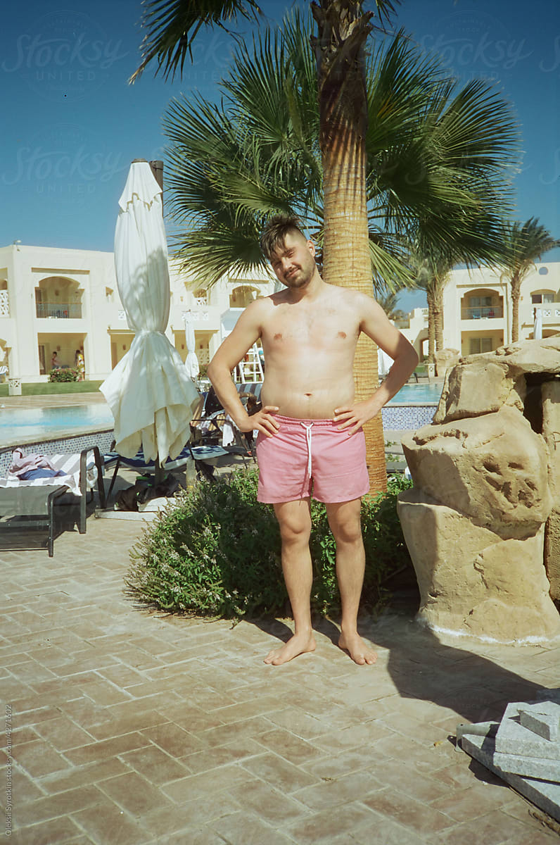 Boy wearing in swimwear posing near swimming pool