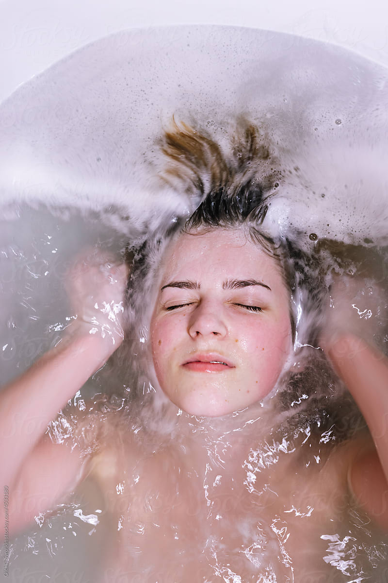 Young girl lying  in bath with bubbles