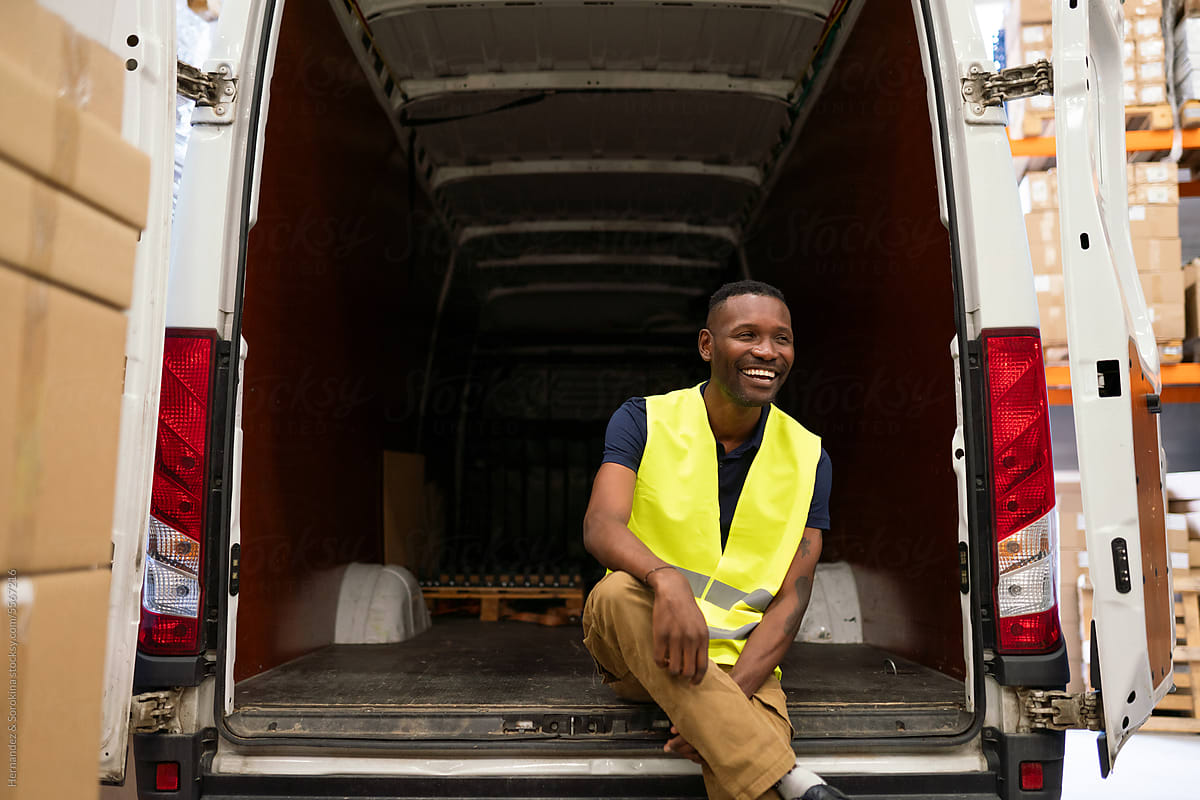 Warehouse Worker Sitting At Open Delivery Van