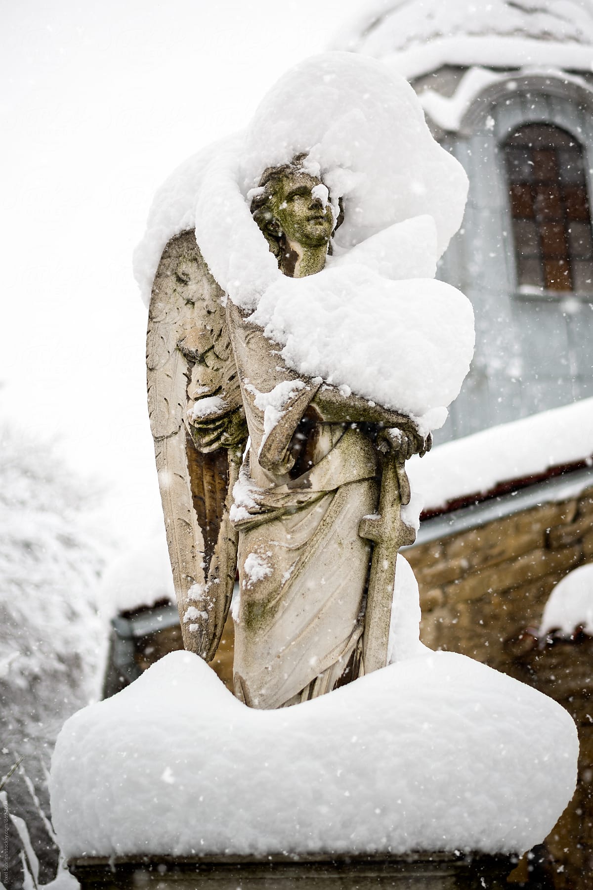 Angel gravestone covered in snow