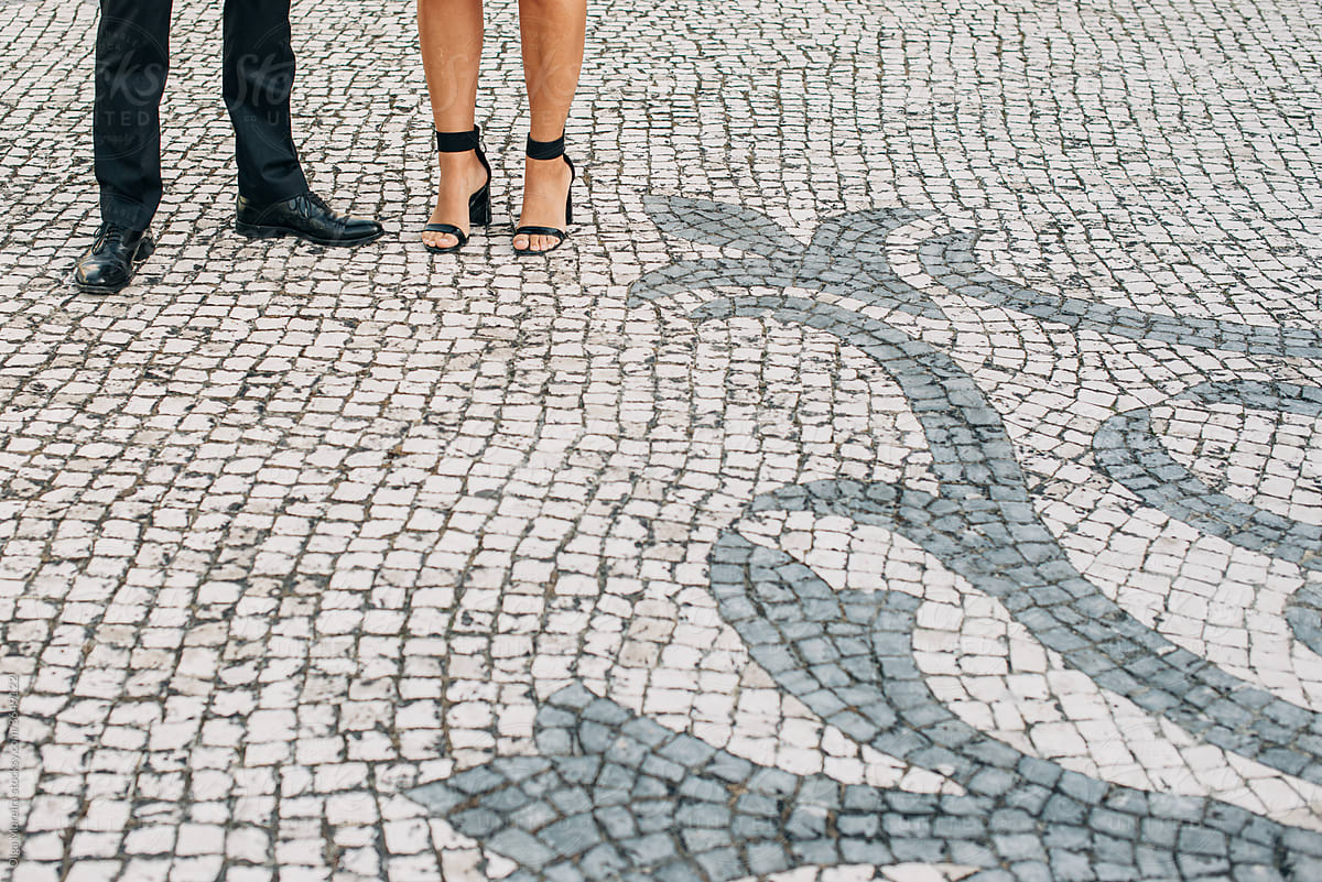 Male and female legs on Portuguese pavement