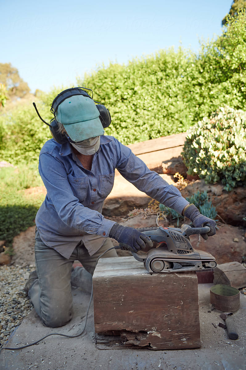 Woman wearing hearing protection whilst using sander