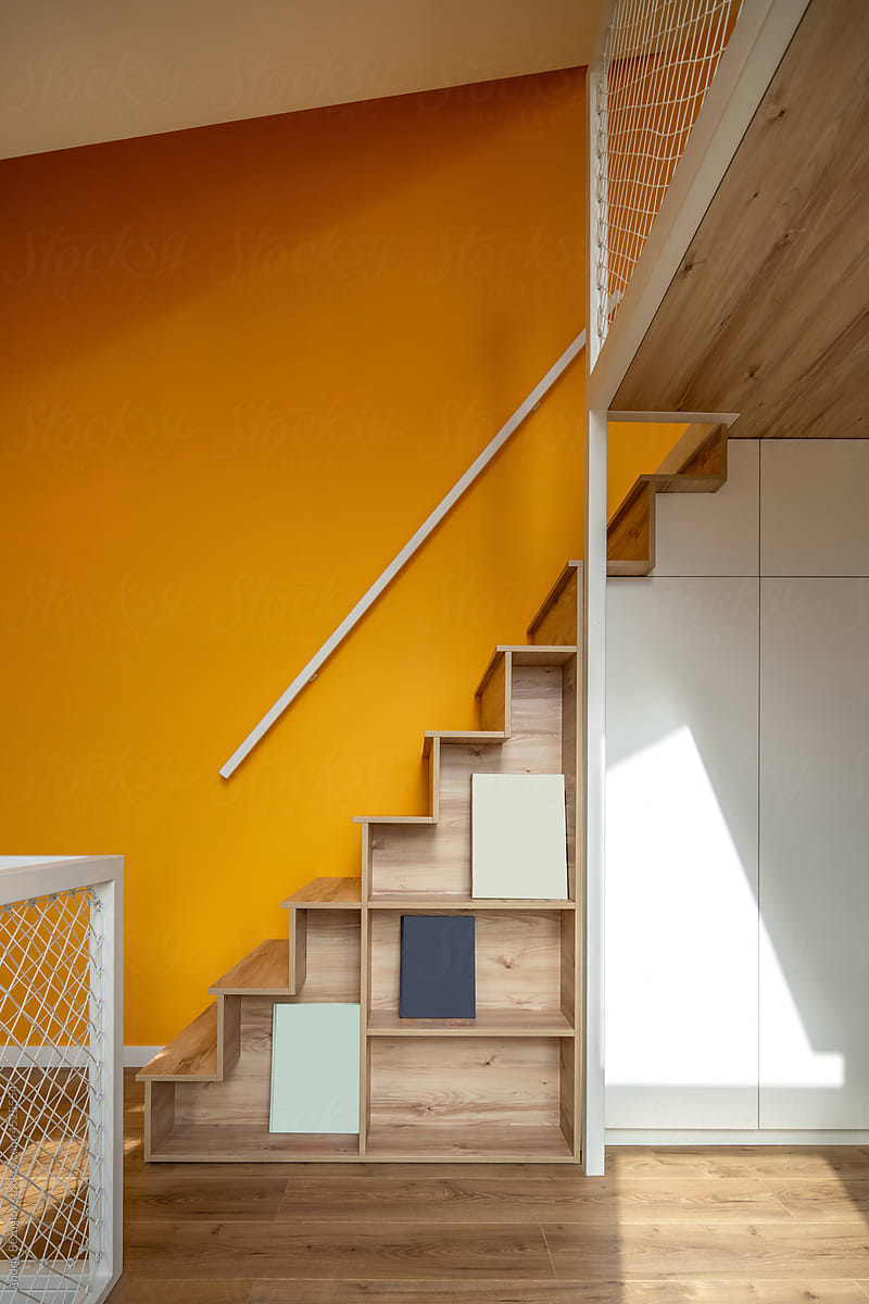 Colorful two-level children\'s room with wooden stairs