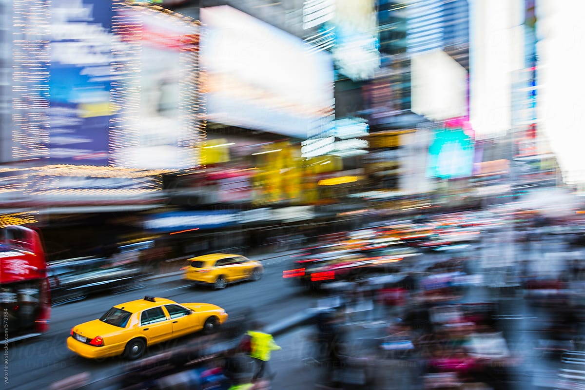 Yellow cab, driving through crowded Times Square in New York City