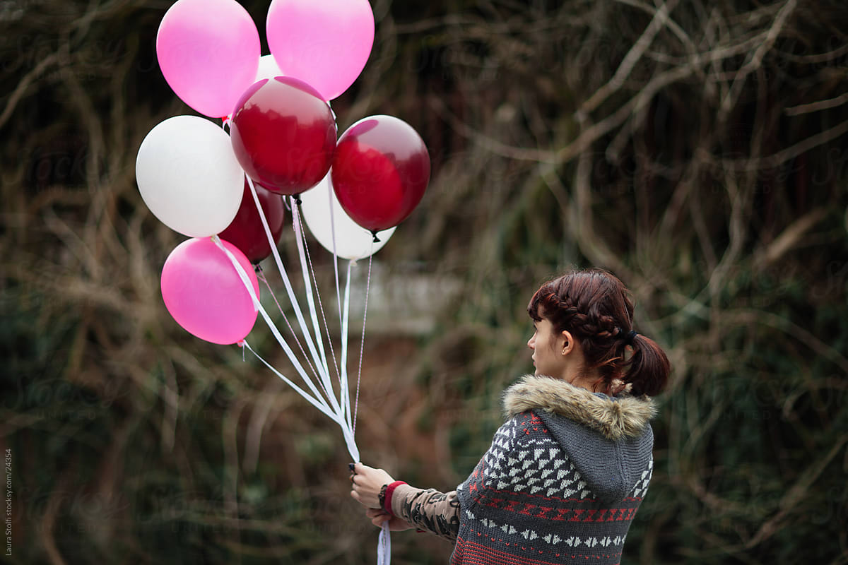 Woman grabbing bunch of balloons