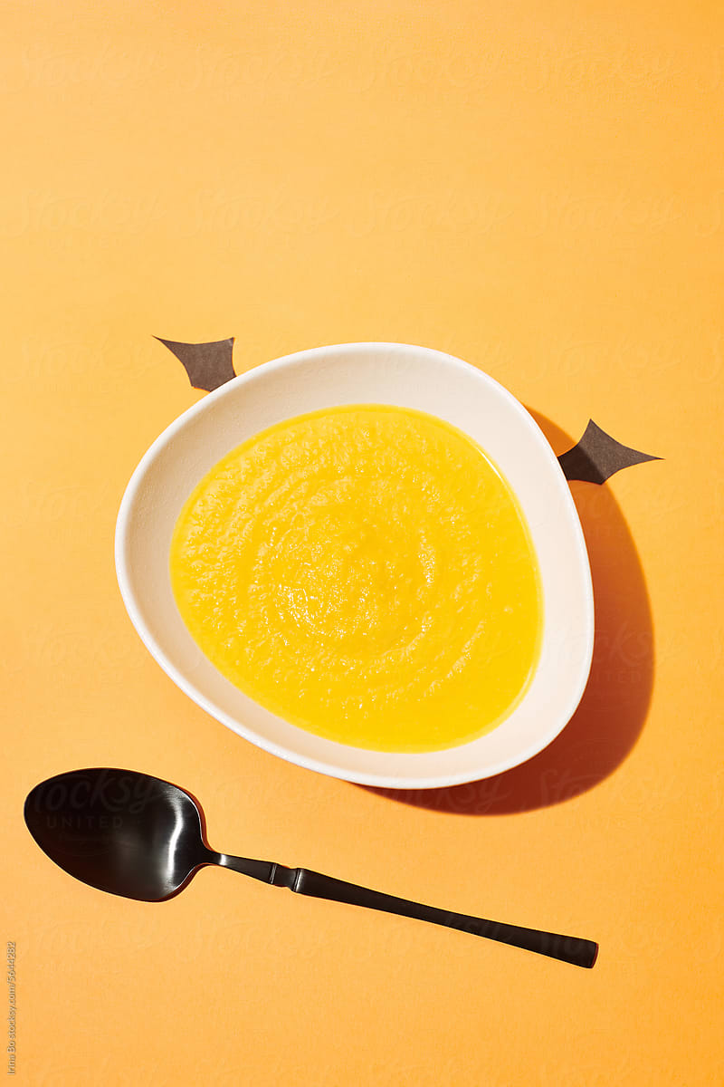 a bowl of carrot ginger soup decorated for Halloween