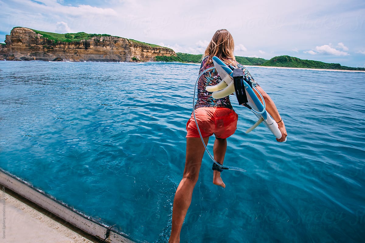 Beautyfull Surfer Girl Jump In Ocean With Surfboard Stocksy United
