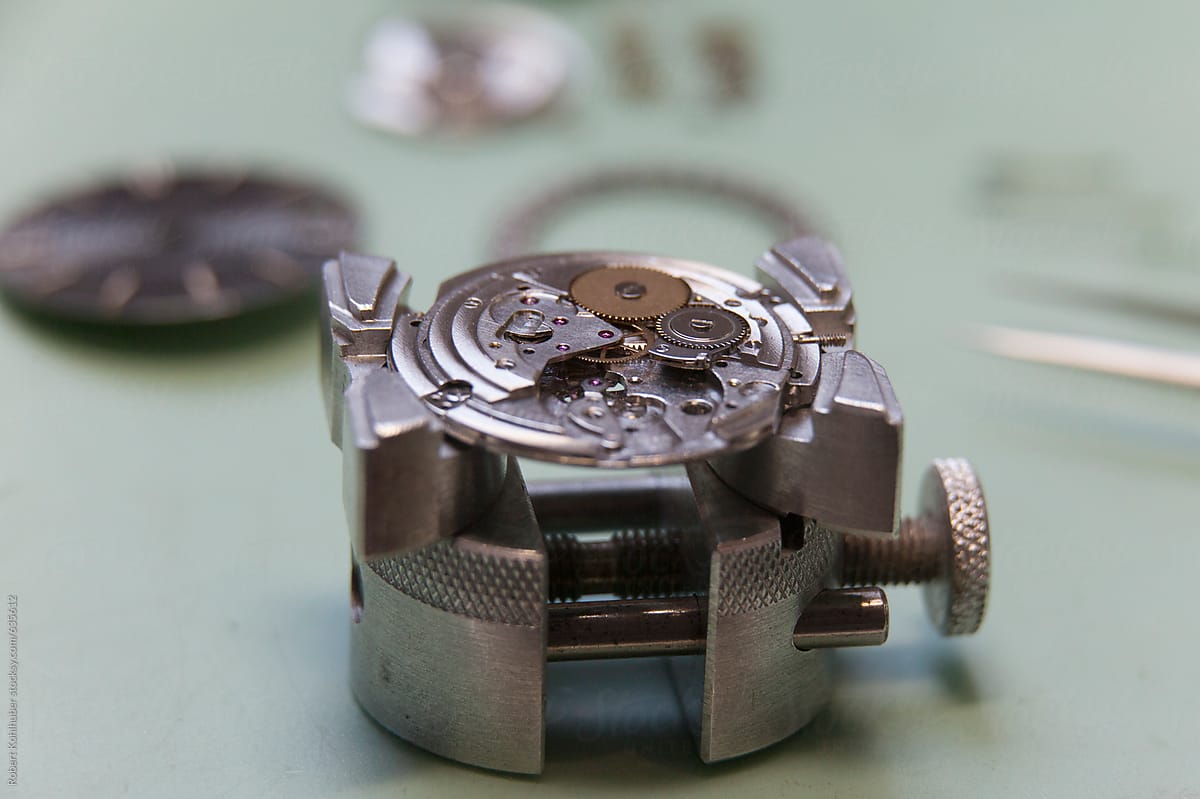 Deconstructed watch lying on clockmaker table