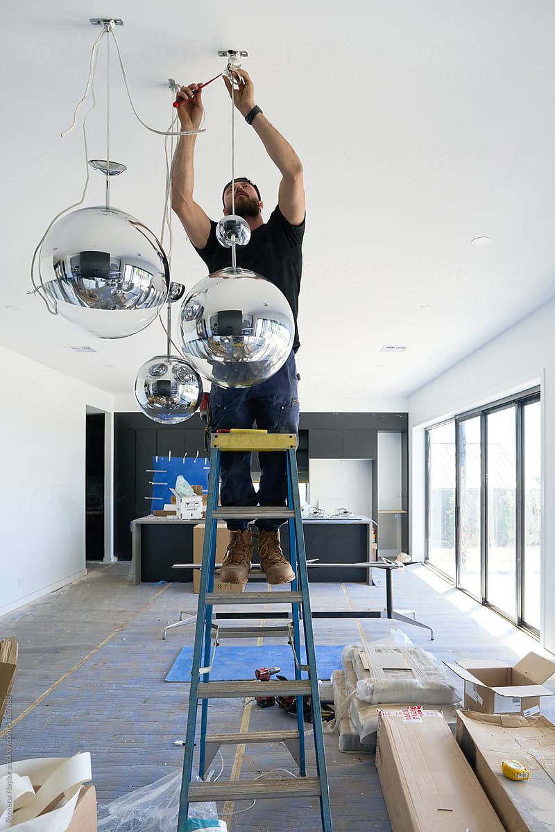 Mirror globe lights being hung by electrician