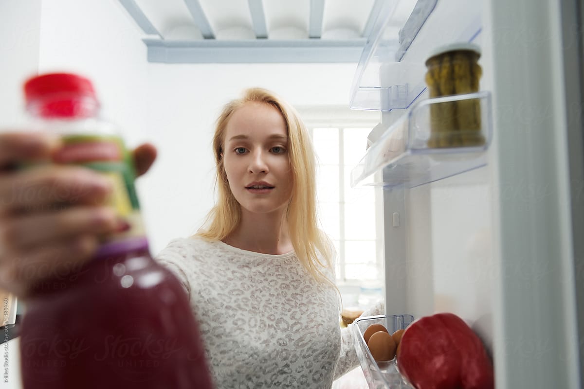 Woman taking bottle from fridge