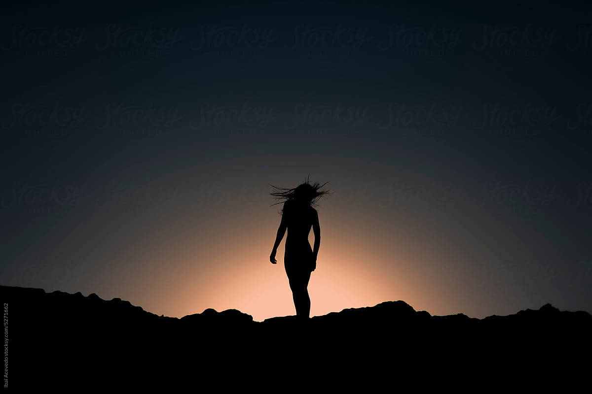 Woman silhouette on surreal windy dark scenery