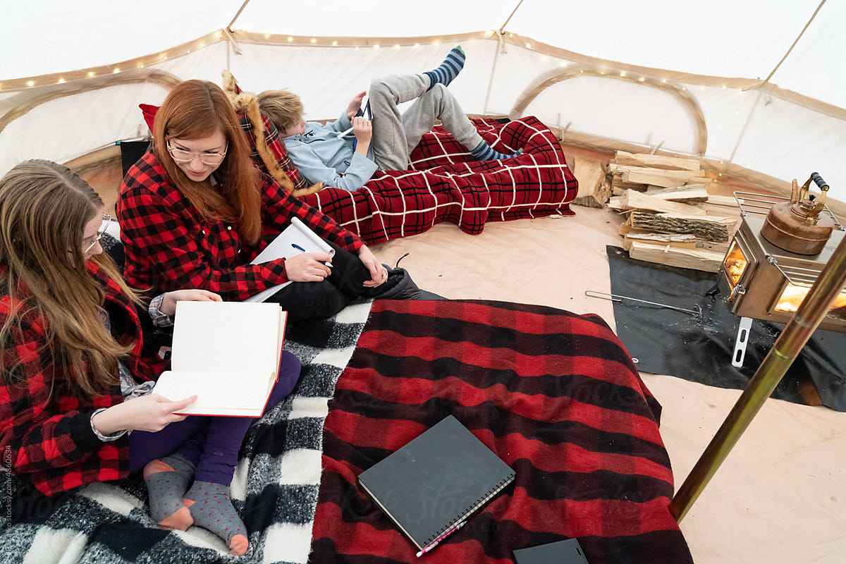 Family Relaxing on Winter Wilderness Trip in Tent